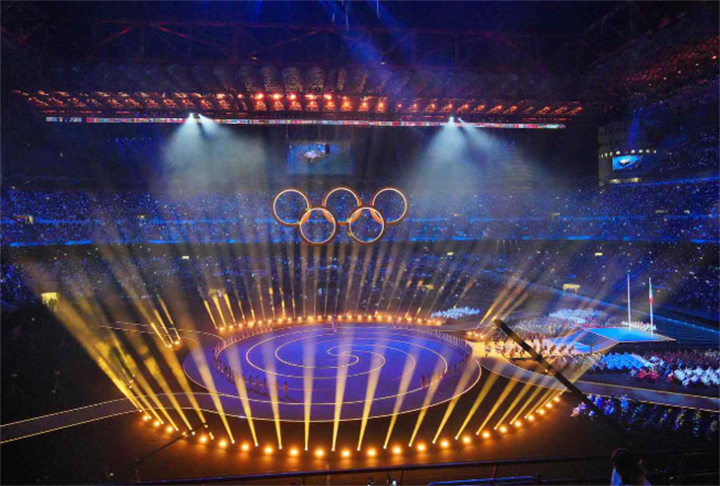 Spectacular Olympic opening ceremony inside a stadium with illuminated Olympic rings and stage lighting