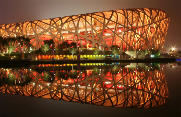 Night view of Beijing National Stadium (Bird's Nest) with water reflection, iconic former Olympic host venue