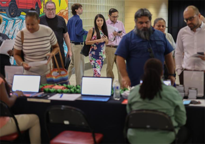 Diverse crowd of job seekers queuing at a service intake desk, illustrating competitive shrinking labor markets