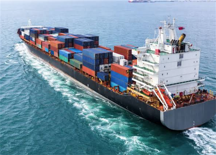 Cargo container ship sailing on open sea, representing logistics costs shifting global coffee prices