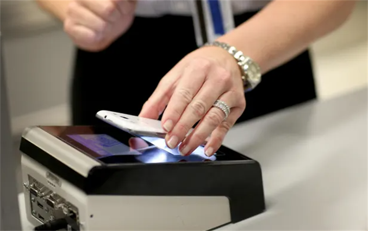 Traveler using a smartphone to scan and verify digital ID at airport security checkpoint