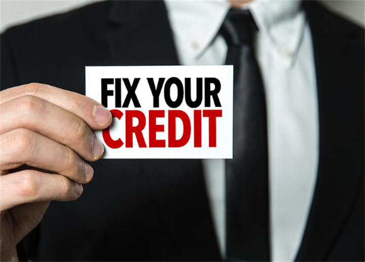 Businessman holding a card printed with 'FIX YOUR CREDIT', advertising credit repair services