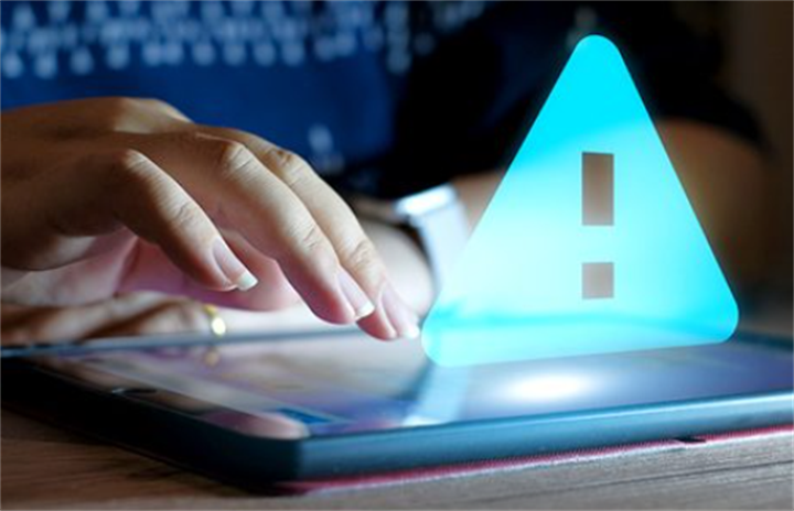 Digital warning triangle alert icon floating over a tablet touchscreen, warning of fake investment scam risks online