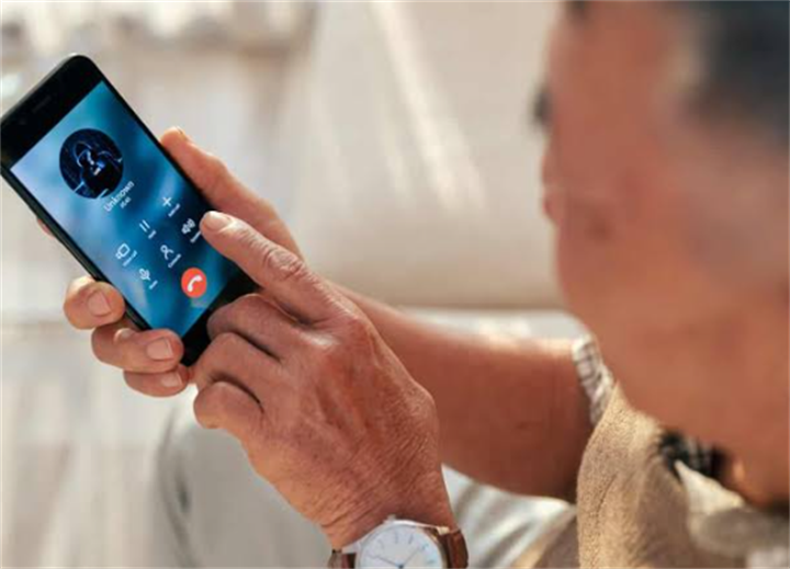 Elderly person receiving an unknown spam phone call, a common entry point for reverse mortgage fraud targeting seniors